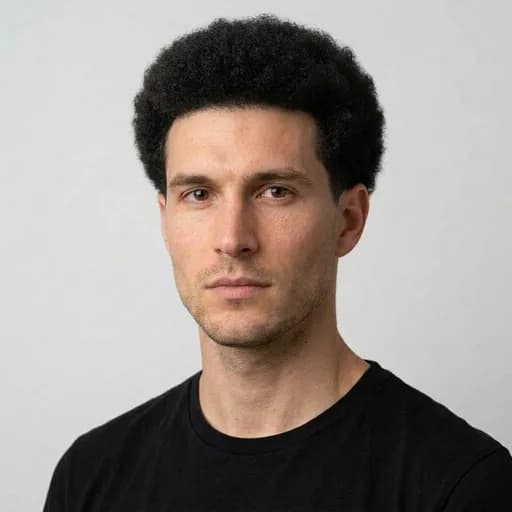 Homme avec la coupe Low taper afro : afro conservé sur le dessus, dégradé bas discret
