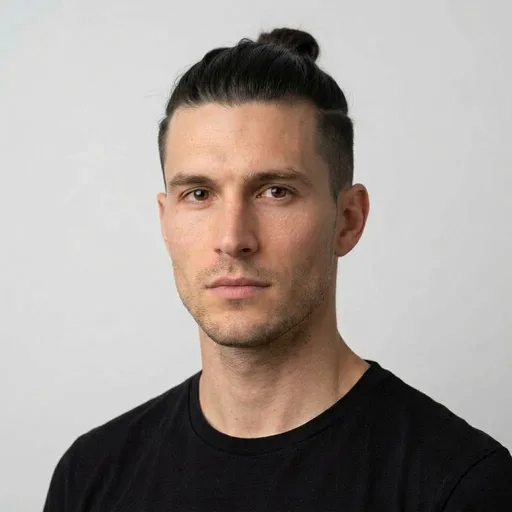 Homme avec la coupe Man bun + undercut : cheveux longs attachés, côtés dégagés